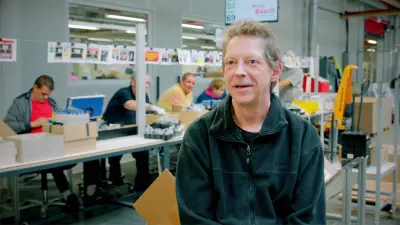 Rob de Bruijn met productielijn op de achtergond.