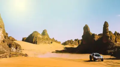 Een elektrische SUV rijdt offroad door een woestijn.